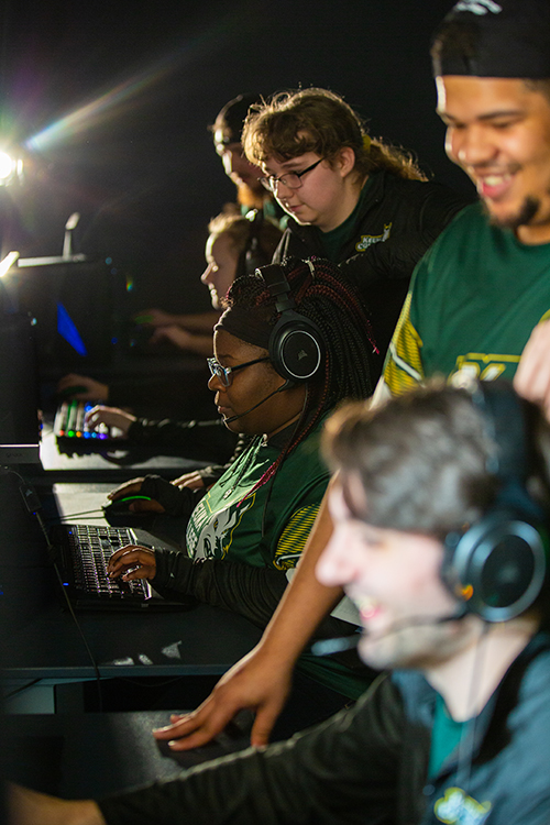 Students gather around an alienware console and play esports.