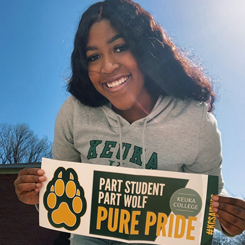 Keuka College Student holding their pure wolf banner