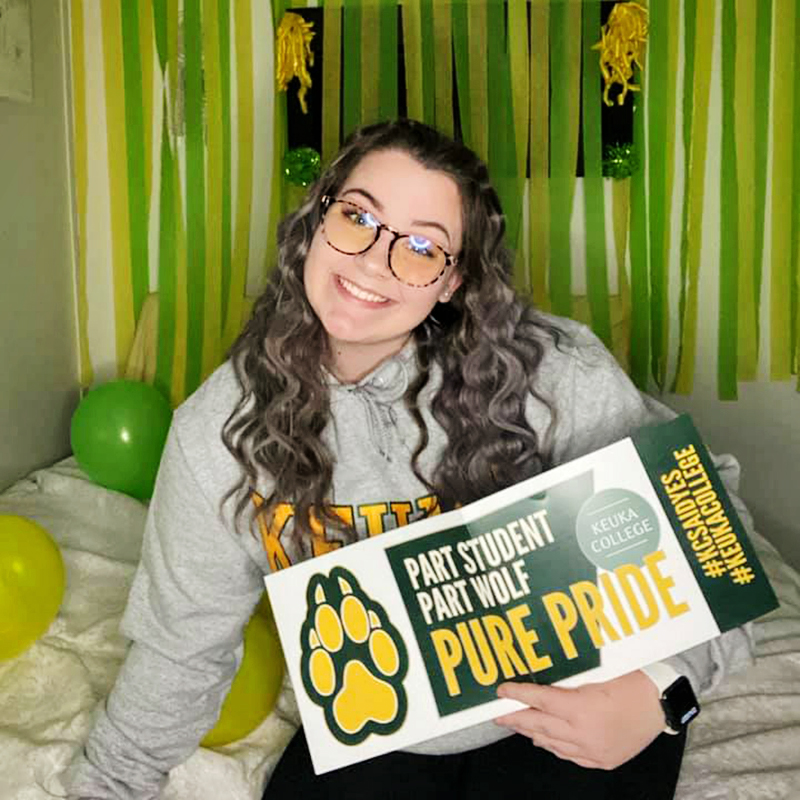 Keuka College Student holding their pure wolf banner