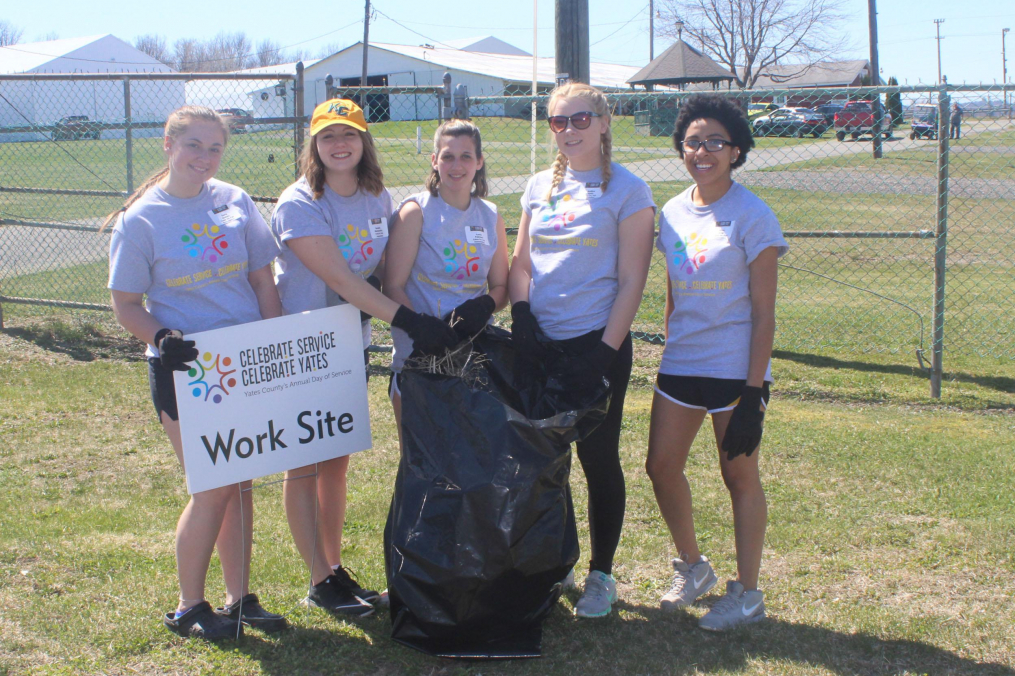 students cleaning a lawn for cscy