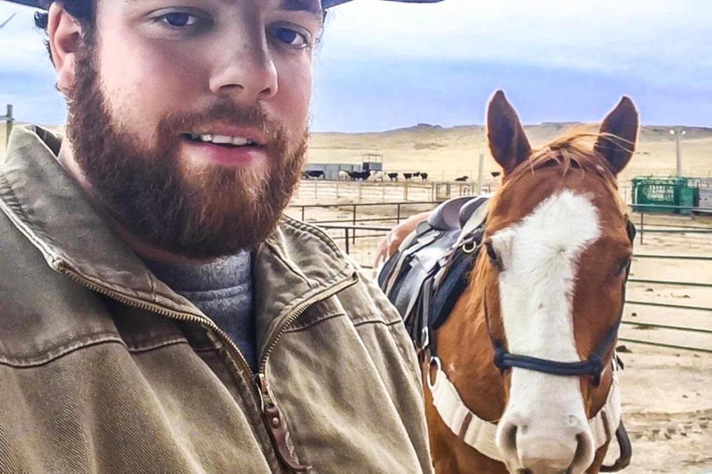 Bryce Bush stands next to a horse