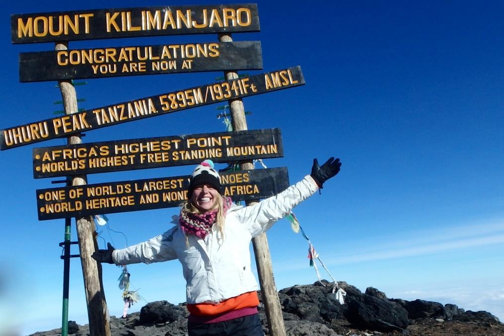 Student stands at the top of Mount Kilimanjaro, the highest point in Africa.