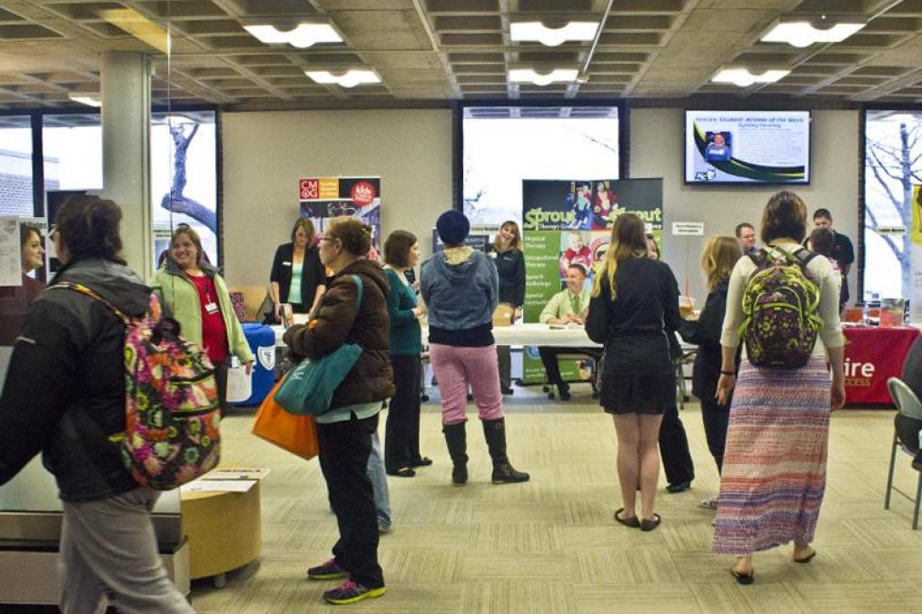 students standing around booths at a career fair