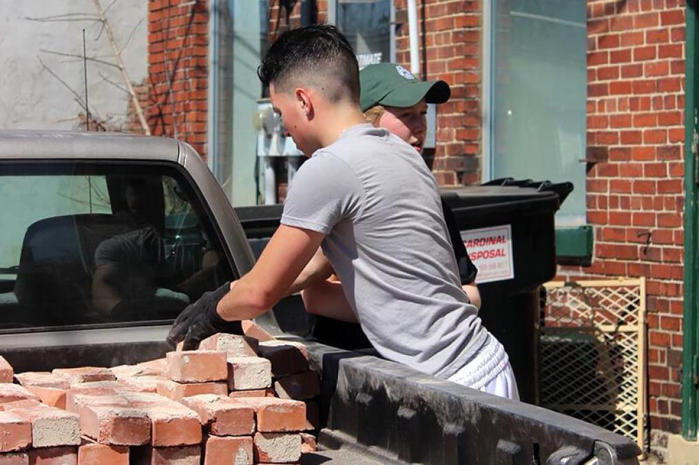 student loading bricks into a truck