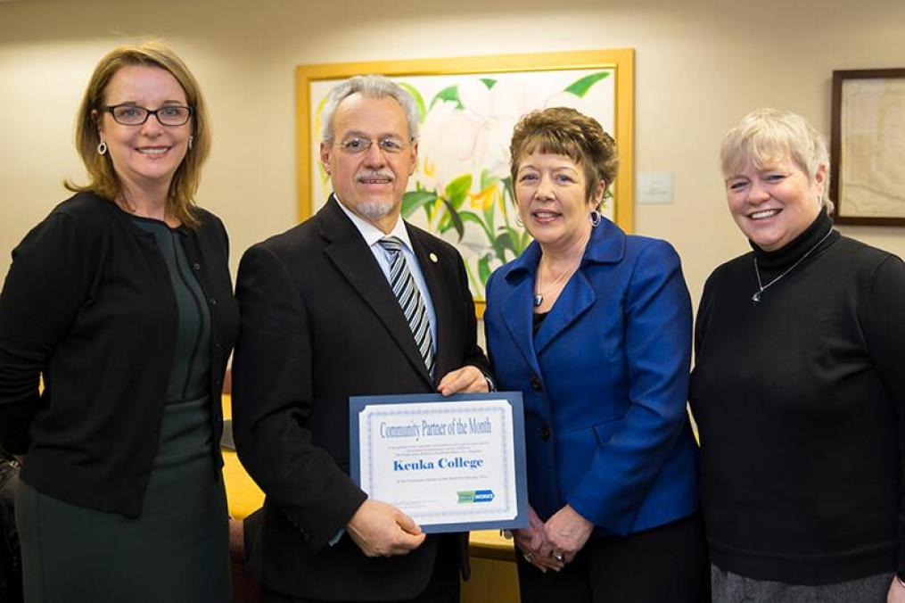 a group of four people holding an award