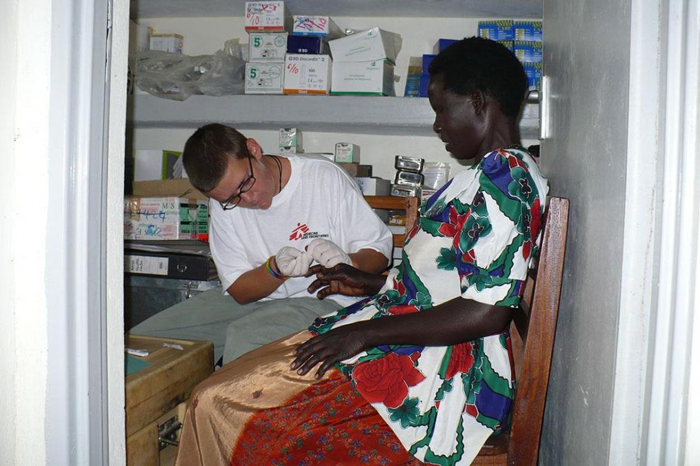 Kellie Lamoreau '97, conducts a paracheck (Malaria test) on a patient in Uganda.
