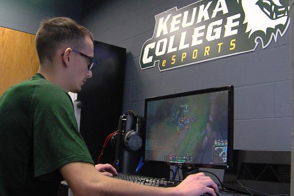 student sitting in front of a computer playing a video game