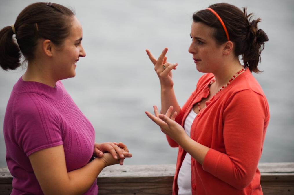 Two girls use sign language near Keuka lake