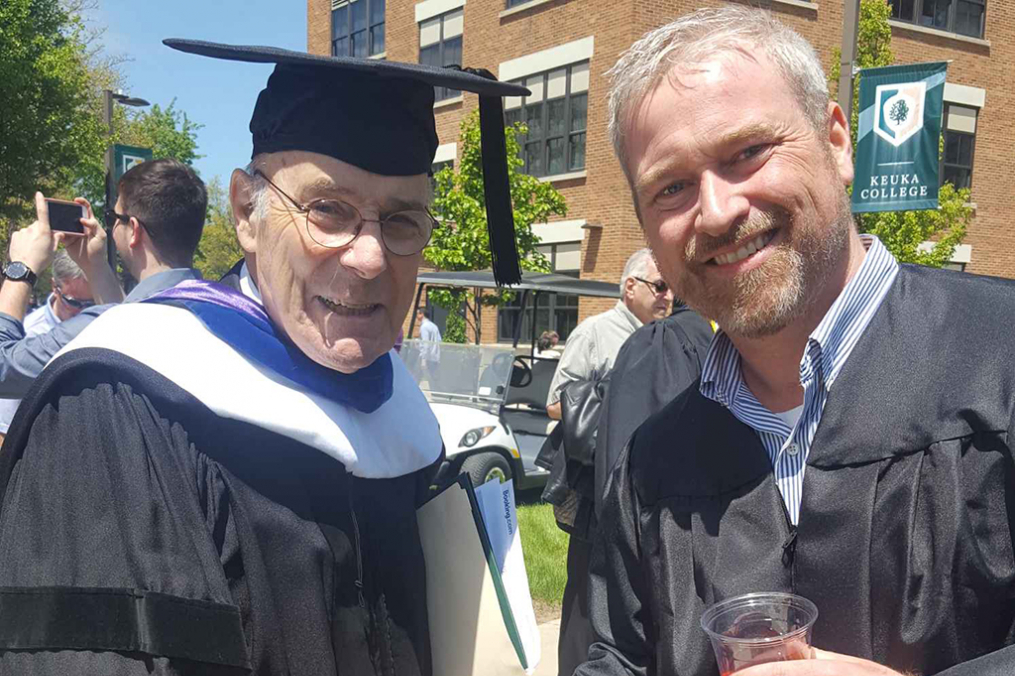 Andrew Bagley '19, right, shares a smile and a handshake with Keuka College's 2019 Commencement Speaker, retired U.S. Ambassador Robert Gosende, following Commencement ceremonies.