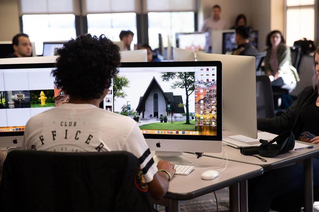 A student sits in the art &amp; design lab working on a photograph of Norton Chapel