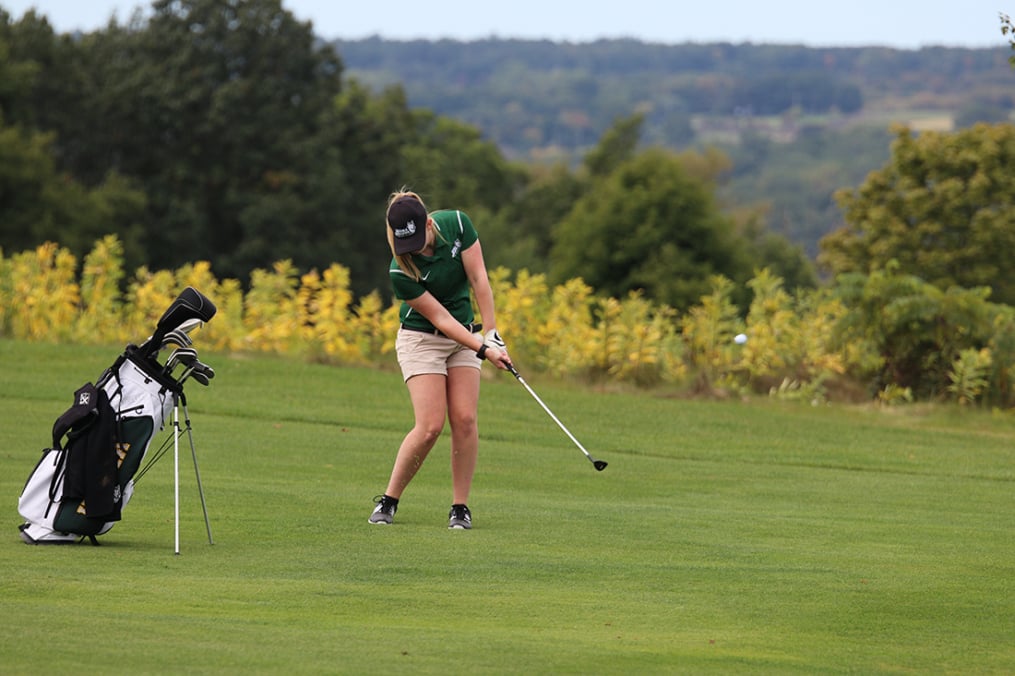 Holly Reynolds chips up during a tournament last fall. She and fellow Keuka College golfer Megan Geariety have excelled for the Wolves.