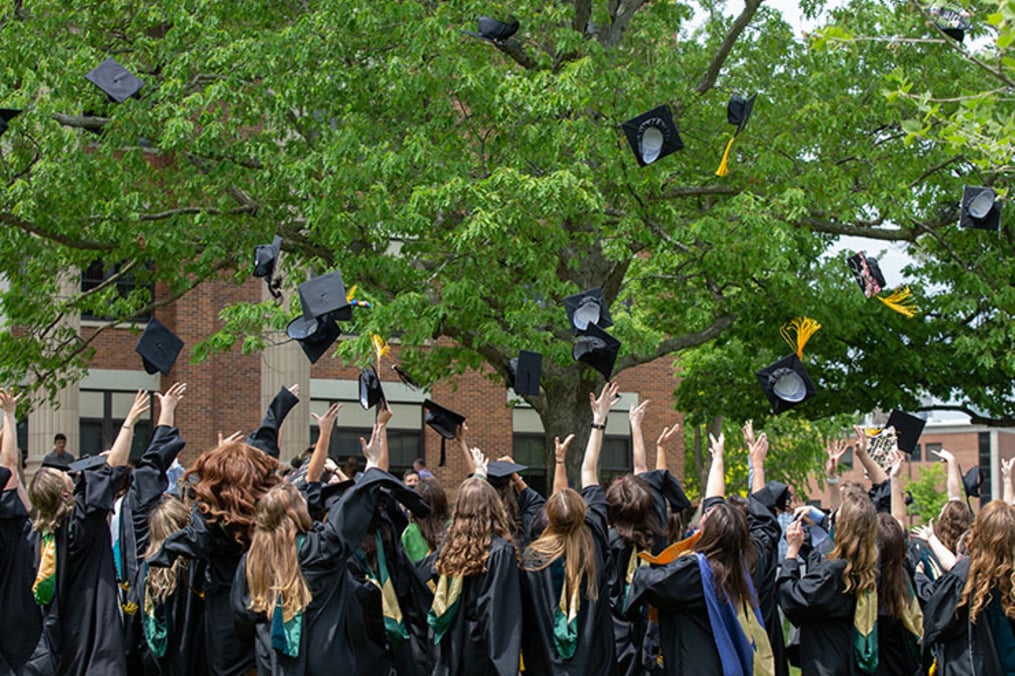 Keuka College graduates toss their caps into the air in celebration after one of six Commencement celebrations the College held on campus May 22-23, 2021.