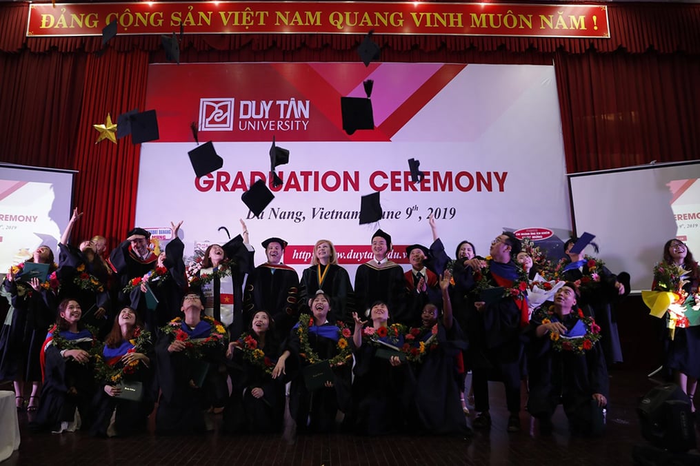 UEF students throwing their caps in the air after graduation