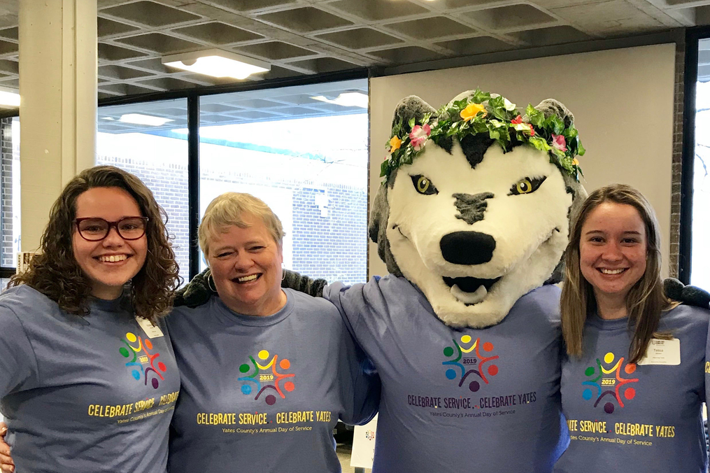 Kacey the Wolf takes a moment to pose with Director of Community Relations and Events Kathy Waye (second from left) and students during the 2019 edition of Celebrate Service...Celebrate Yates. 