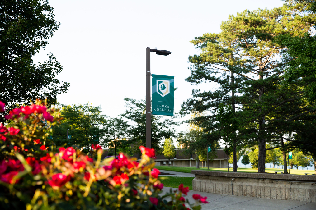 Image of Keuka College banner hung on a lamp pole in the center of campus 