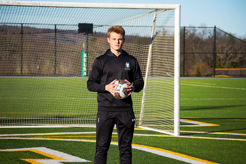 Carson Smith '26 holding soccer ball in front of goal on Keuka College's soccer field