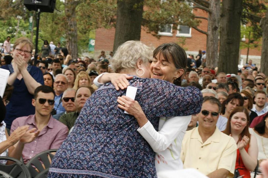 Karen Mann, right, director of conference services, gets a hug from colleague Kathy Waye after being named Staff Member of the Year.