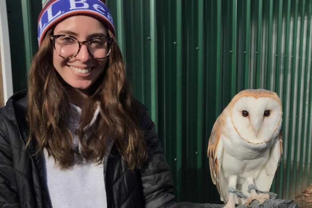 Grace DelRossa posing with a white owl standing on her left hand