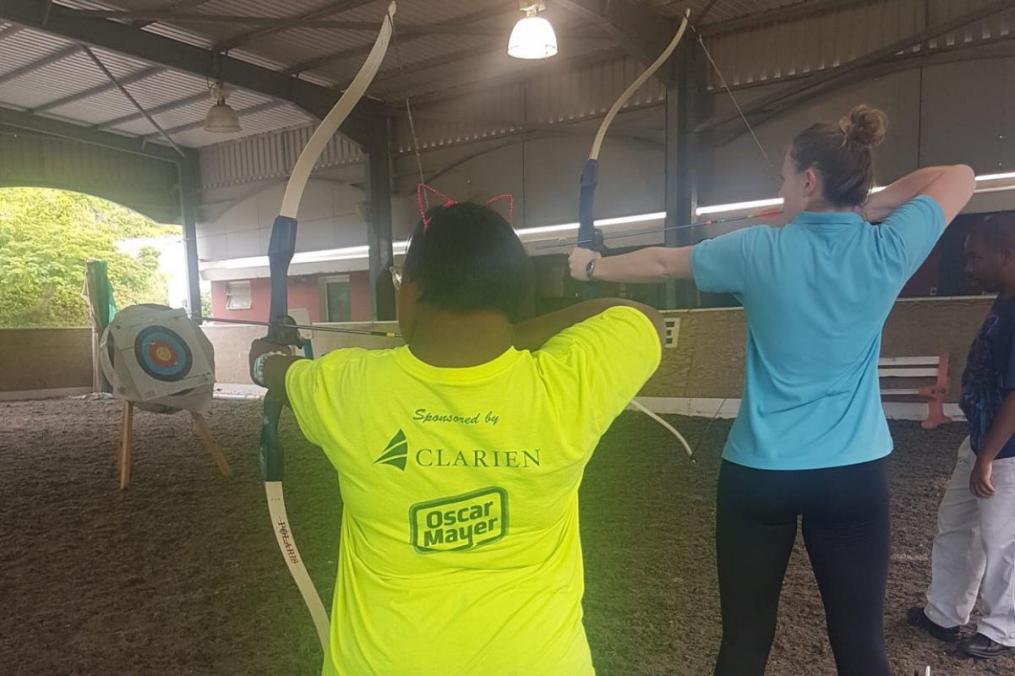 Meg Calhoun '18 (right) helps one of her students practice archery.