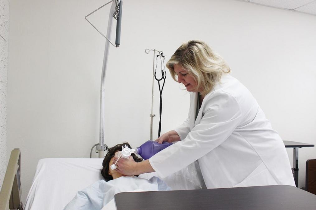 Dr. Elizabeth Russo '98, chair of the Division of Nursing, demonstrates how to use a CPR bag-mask on a mannequin in the College's new nursing lab.