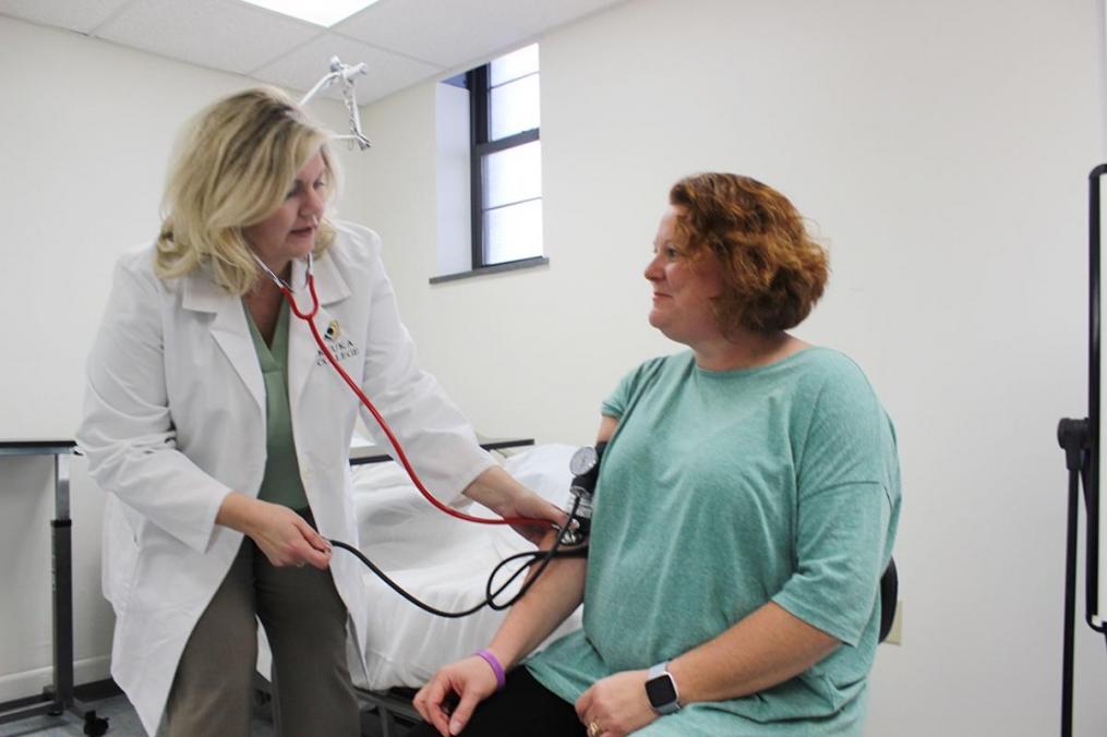 Dr. Elizabeth Russo '98, chair of the Division of Nursing (l), demonstrates how to take blood pressure on Dr. Susan Bezek, assistant professor of Nursing, in the College's new nursing lab.