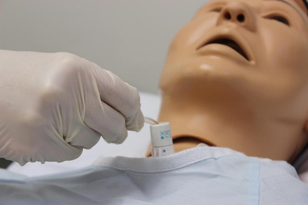 Dr. Elizabeth Russo '98, chair of the Division of Nursing, demonstrates how to use the College's tracheostomy equipment in the College's new nursing lab.