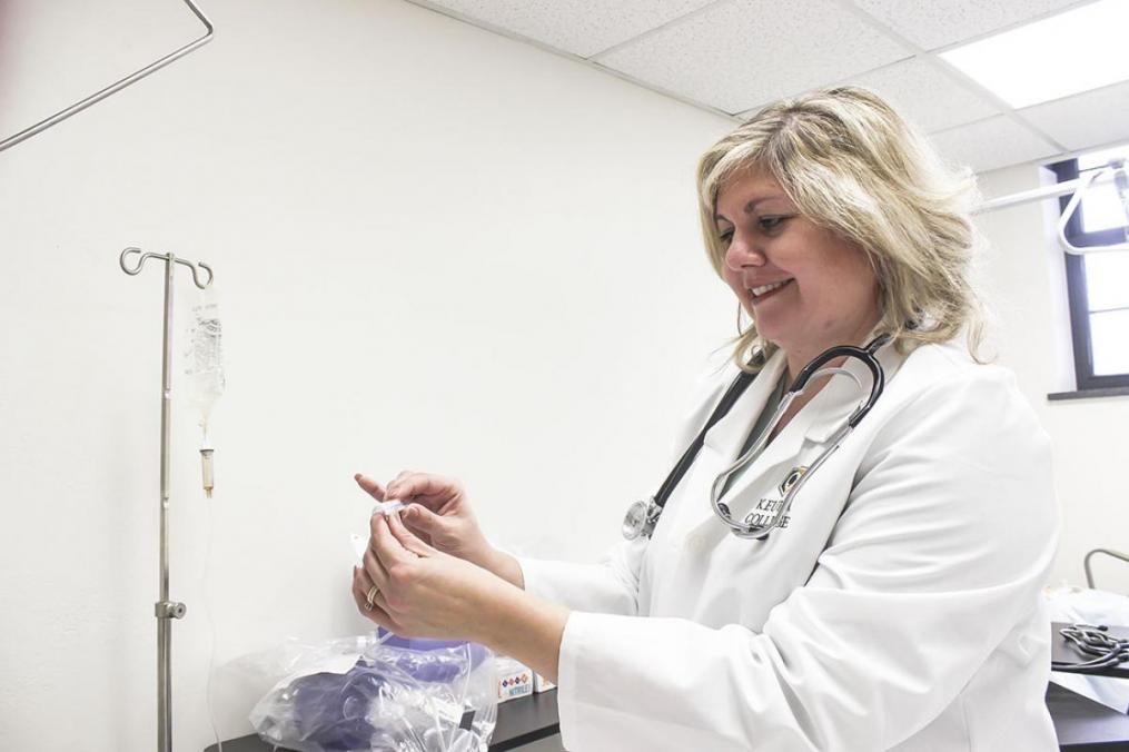 Dr. Elizabeth Russo '98, chair of the Division of Nursing, reads a thermometer in the College's new nursing lab.