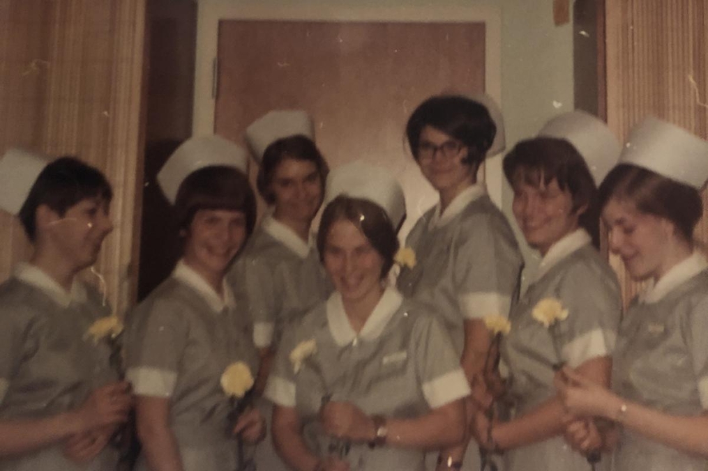 Keuka College Class of 1971 Nursing students standing in a row each holding a yellow carnation