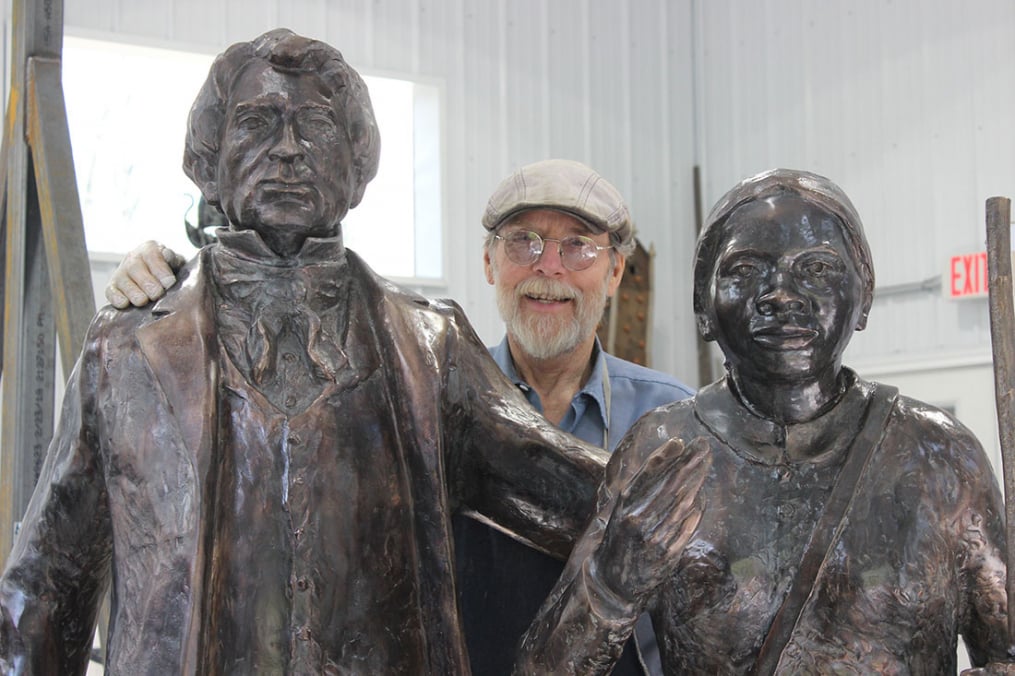 Professor Emeritus Dexter Benedict, sculpted life-sized statues of William Seward (l) and Harriet Tubman. They will be installed at the Schenectady County Public Library in Schenectady, N.Y. Above, he poses in the middle of his latest works.