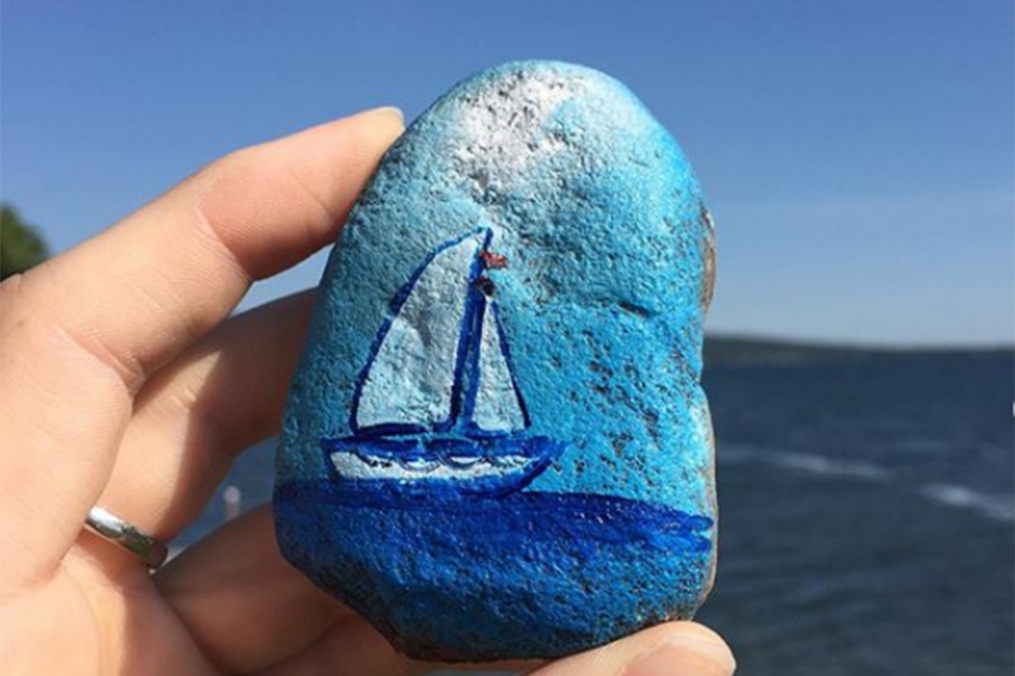 sail boat painted in blue on a rock