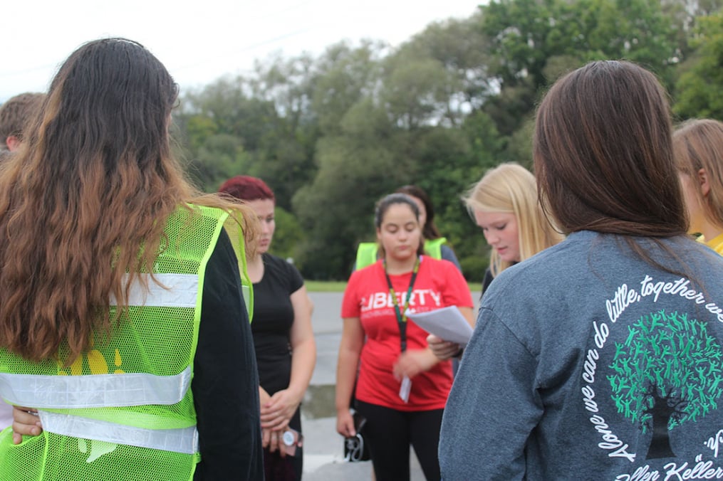 A group of students pause during the 2017 One Walk to listen to statistics about suicide.