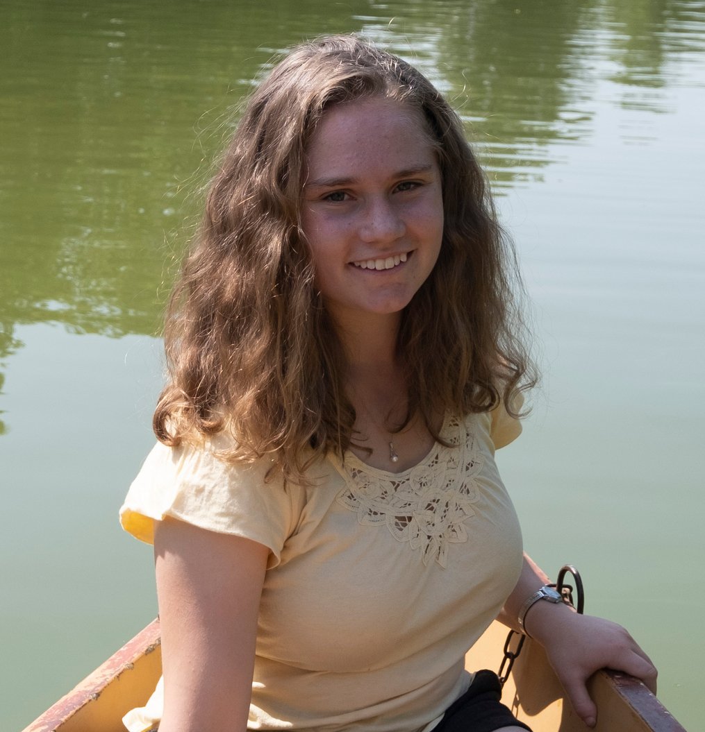 Molly sitting in a boat with the water behind her