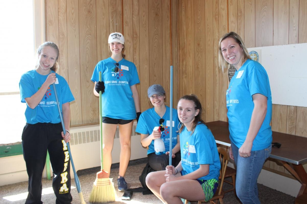 students cleaning a room with brooms