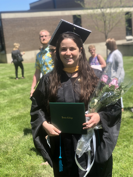 Monica Leljedal poses at graduation in her gown 