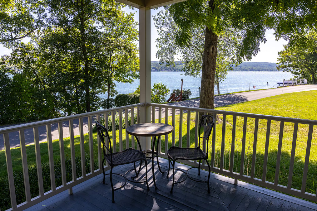 Small bistro table with 2 chairs in the corner of the porch of the alumni house