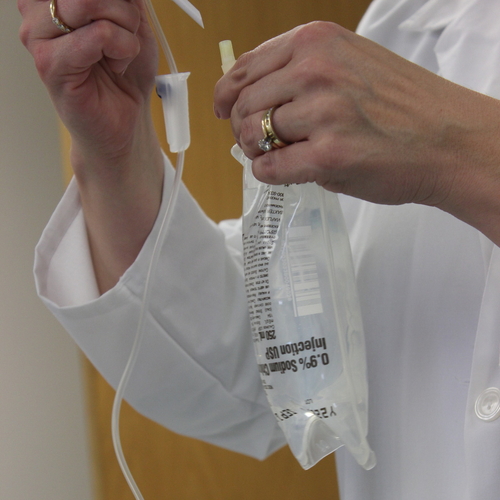 nurse or doctor holding an IV getting it ready to use on a patient