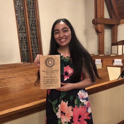 Rocio Figueroa posing with an award in the Chapel