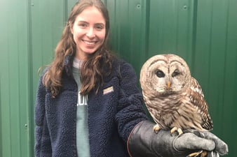 sophomore Grace DelRossa posing for a photo with an owl sitting on her left hand